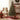Artificial Christmas tree with warm lights, red baubles, and metal stand base.