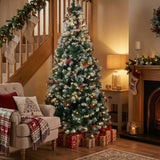 Artificial Christmas tree with lit branches, red baubles, on metal stand.