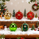 Christmas ornaments on snowy wooden display: gold, red, green baubles and teardrops