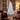 Pre-lit artificial Christmas tree with white LED lights on metal stand, full height view