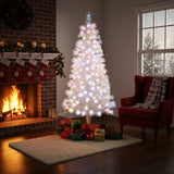 Pre-lit artificial Christmas tree with warm white LED lights on metal stand, full tree