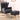 Dark grey wingback armchair with matching footrest and wooden legs, upholstered arms.
