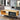 Wood coffee table with drawer front and open storage, light wood and black base