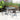 Outdoor patio dining set with 4 chairs and table; dark woven chairs and glass top
