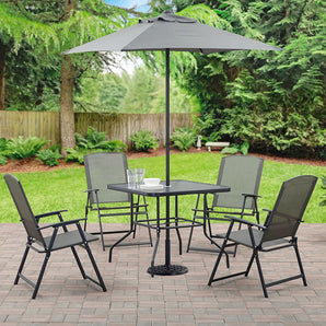 Outdoor dining table with square glass top, black metal frame, and parasol hole