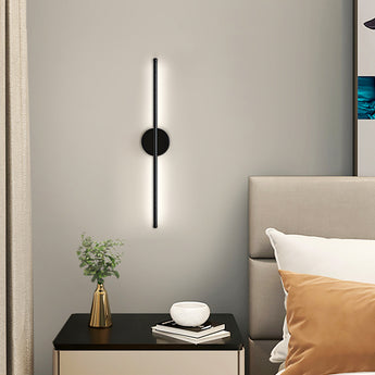Black linear LED wall sconce with round backplate and vertical bar, white light