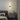 Black linear LED wall sconce with round backplate and vertical light bar, warm glow