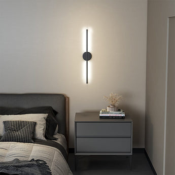 Black linear LED wall sconce with round backplate and vertical light bar, warm glow