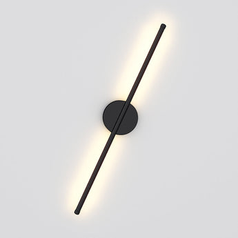 Black linear LED wall sconce with round mounting plate and diagonal vertical bar, warm glow
