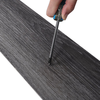 Dark grey woodgrain PVC plank edge, adhesive backing and cutting line