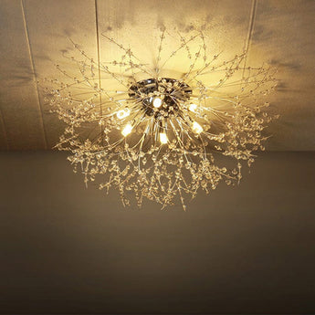Gold Sputnik flush mount ceiling light, glowing central bulb and dangling strands