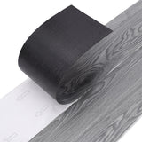 Grey wood-effect PVC flooring roll edge with attached backing