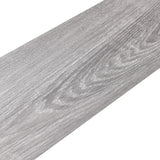 Close-up gray wood-effect PVC flooring plank showing detailed grain and knots