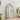 Tall arched window mirror in metal frame, wall-mounted view from side