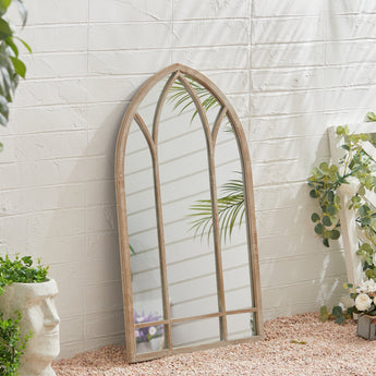 Tall arched window mirror in metal frame, wall-mounted view from side