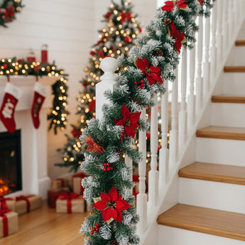 Artificial LED Christmas garland with red poinsettias and warm white lights on railing