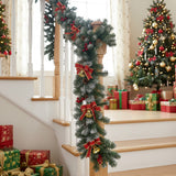 Artificial LED Christmas garland with red bows and warm white lights on stair post