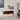 Freestanding electric fireplace with white mantel and dark interior, glowing orange flame effect.