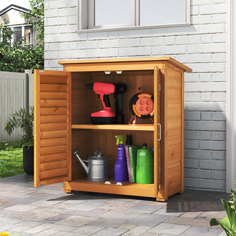 Outdoor wooden storage shed with doors open, interior shelves holding garden tools