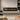Wall-mounted electric fireplace insert with dark glass viewing window and orange flame effect
