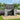 Outdoor metal garbage storage shed, dark gray, hinged lid open with double doors