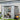 Metal garden storage shed with double doors, ventilated roof, interior shelving visible