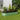 Light green oval raised garden bed with trellis support and soil-filled interior