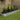 Silver oval raised garden bed with flowering plants and green trellis frame