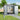 Gray storage shed with double doors open, showing interior shelving and tools