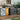 Outdoor metal storage shed, double doors open with yellow bin and recycling labels