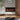 Black wall-mounted electric fireplace insert with orange flames and faux logs