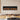 Black electric fireplace inset on stone wall with orange flame display and logs