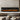 Black electric fireplace with bright orange flames behind glass, recessed in wall