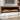 Wall-mounted black electric fireplace with realistic orange flame effect behind glass front