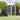 Black steel garden shed with open front door, gabled roof vents, and storage shelves