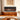 Electric fireplace with black surround, flame insert, and wooden base