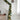 Green pine garland with gold ornaments and warm LED lights draped on white stair railing