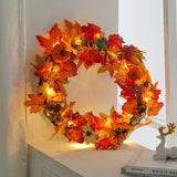 Autumn leaf wreath with orange, yellow, and red foliage and warm string lights
