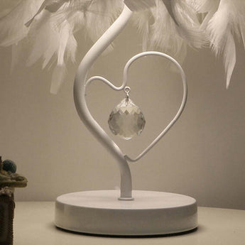 Heart-shaped metal stand with clear crystal pendant under white feather lampshade