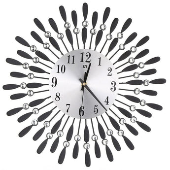 Close view of a metal sunburst wall clock with round face, black numerals, and crystal bead drops.