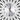Wall clock close-up showing round white dial, black numerals, gold center, and crystal-studded spokes.