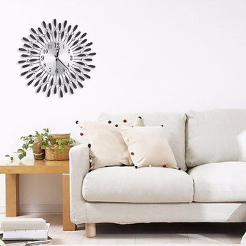 Metal wall clock featuring a round dial and sunburst spokes with crystal bead details.