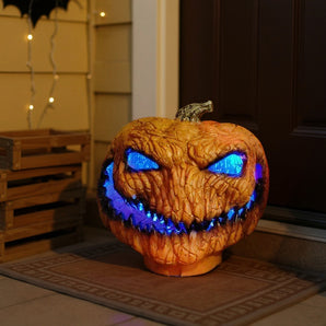 Spooky LED light-up pumpkin with bright blue glowing eyes and jagged mouth, orange textured