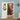 Lighted wreath snowman door decor hanging on door, plaid top hat and warm lights