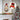 Lighted wreath snowman door decor on wall with plaid hat, burlap bow, warm light glow