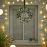 Hanging Christmas wreath with gray bow, pine branches, and sparkling bauble ornaments