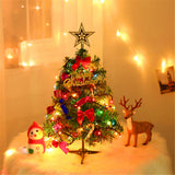 Artificial mini tabletop Christmas tree with gold star topper, red ribbons, and multicolor LED lights
