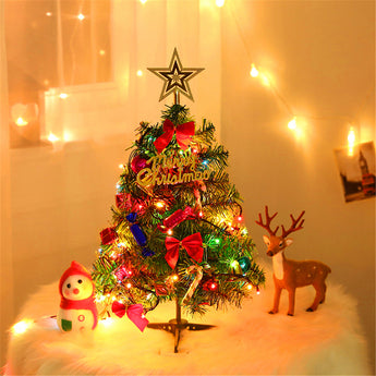 Artificial mini tabletop Christmas tree with gold star topper, red ribbons, and multicolor LED lights