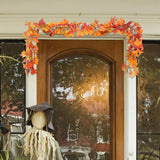 Top section of hanging maple leaf garland with warm LED lights and orange-red leaves