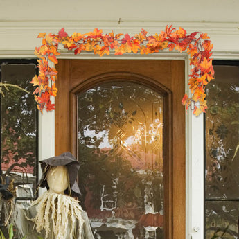 Top section of hanging maple leaf garland with warm LED lights and orange-red leaves